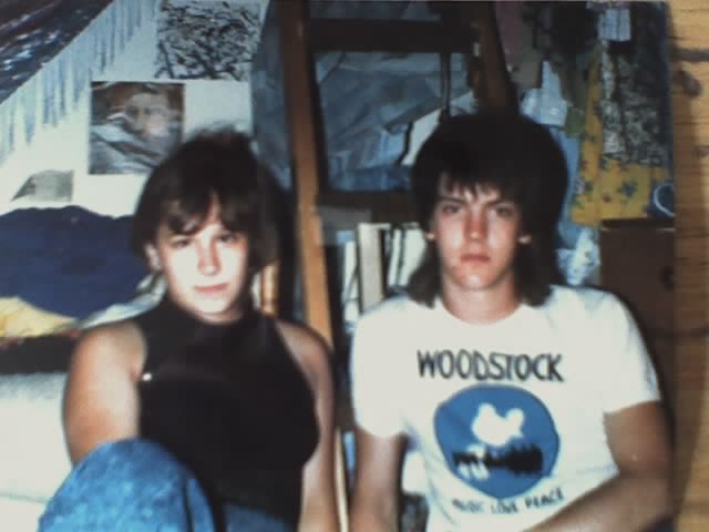 two white young people, me in sleeveless crop top, guy with mullet in a Woodstock tshirt