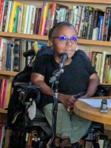 yomi in powerchair, with the microphone