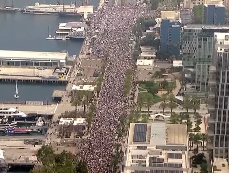 multiple city blocks of a very wide crowd along a waterfront street in san diego